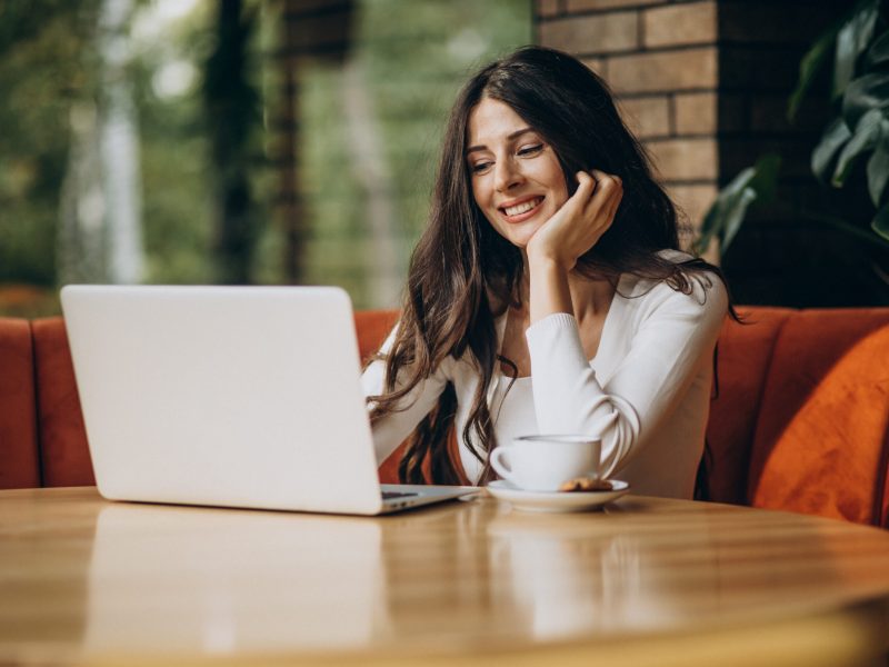 Young beautiful business woman working on cimputer in a cafe